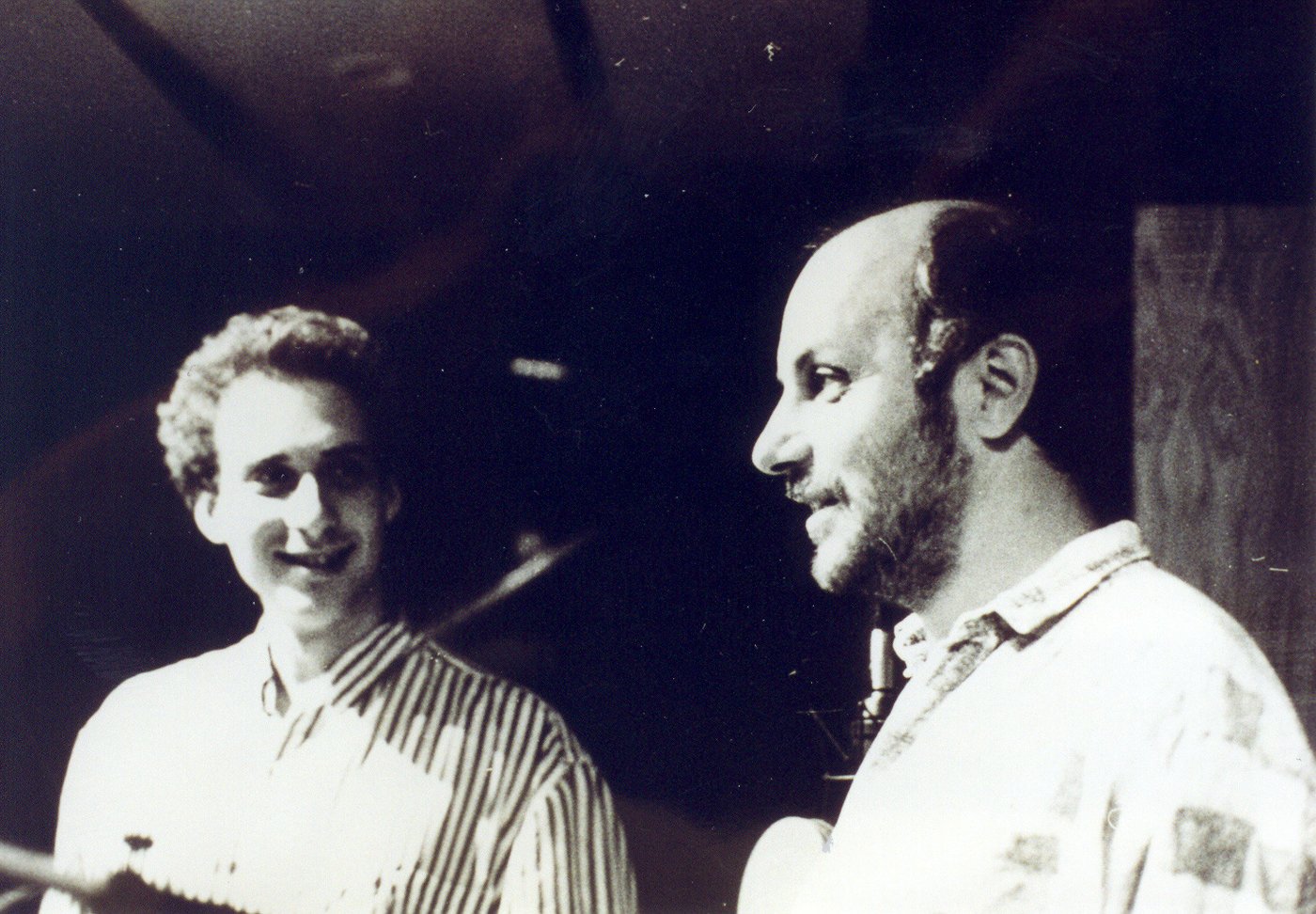 Grego as a young man beside Attila László in a recording studio, a microphone behind them