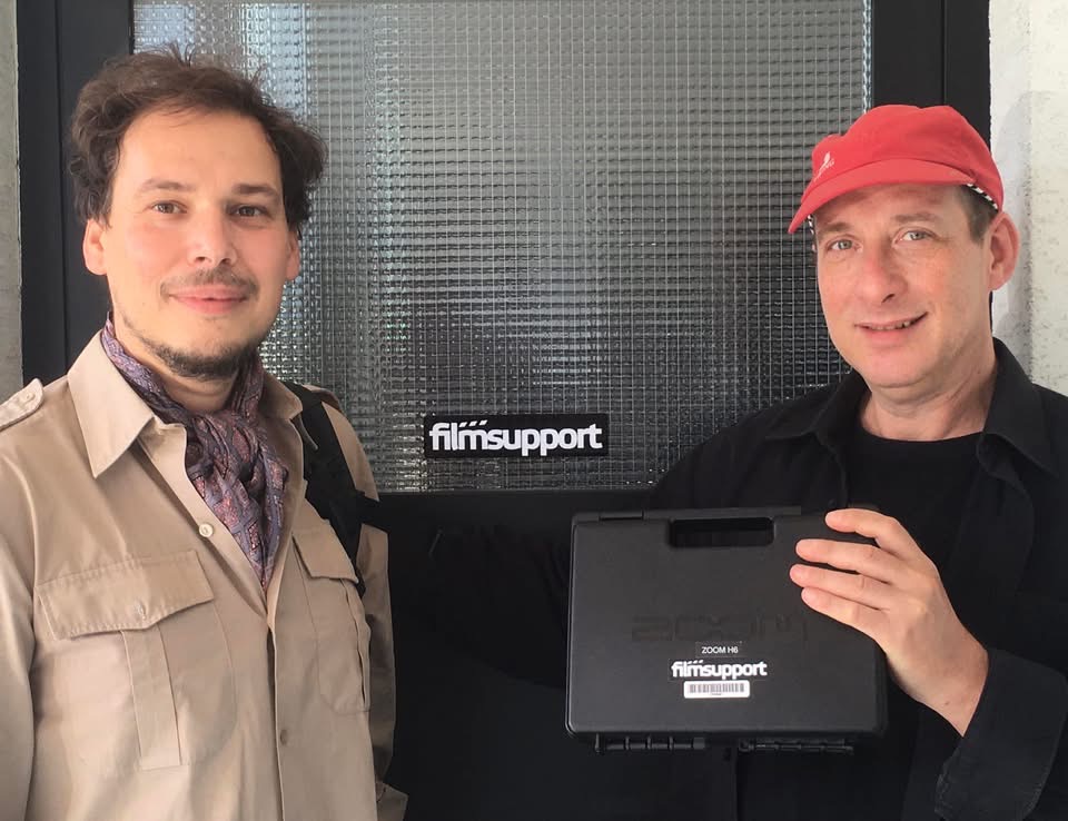 Grego and Ladislav Pálmai outside Filmsupport holding a recorder case