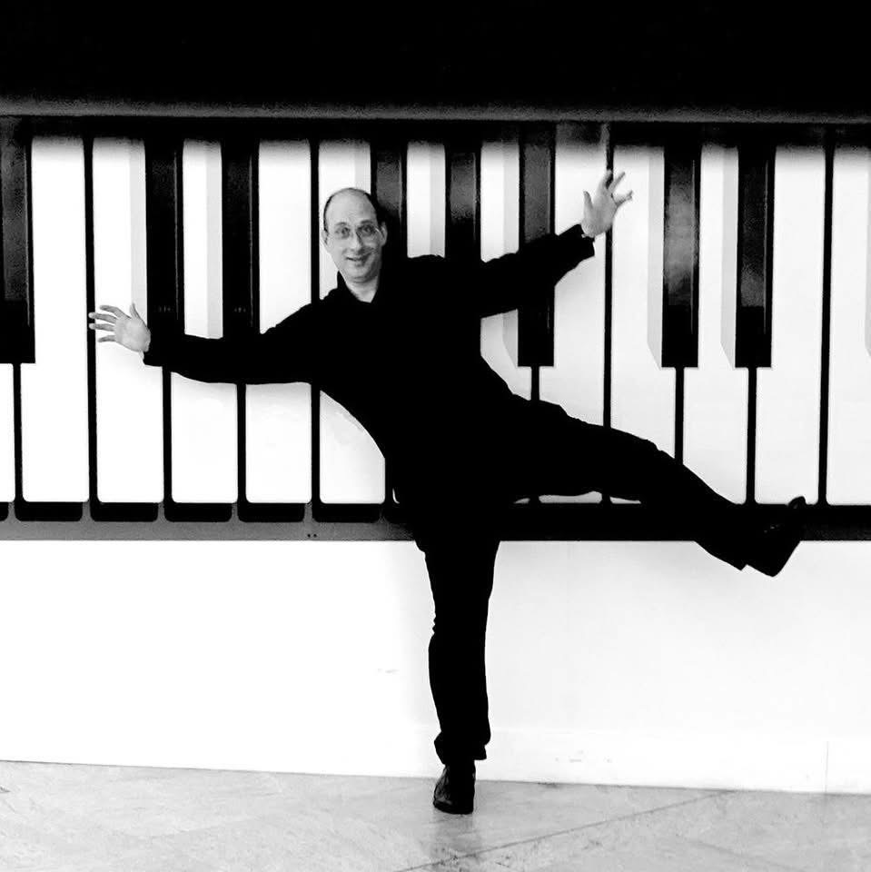 Grego stretched across a giant painted piano keyboard