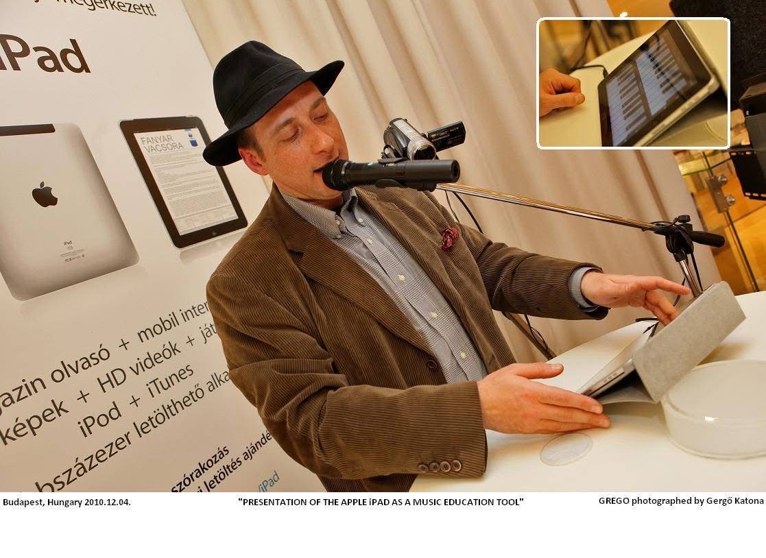 Grego in a hat playing a tablet on a stand at an Apple iPad display