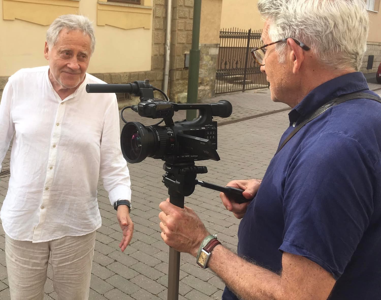 Róbert Koltai talking to camera while István Jávor films him in a street