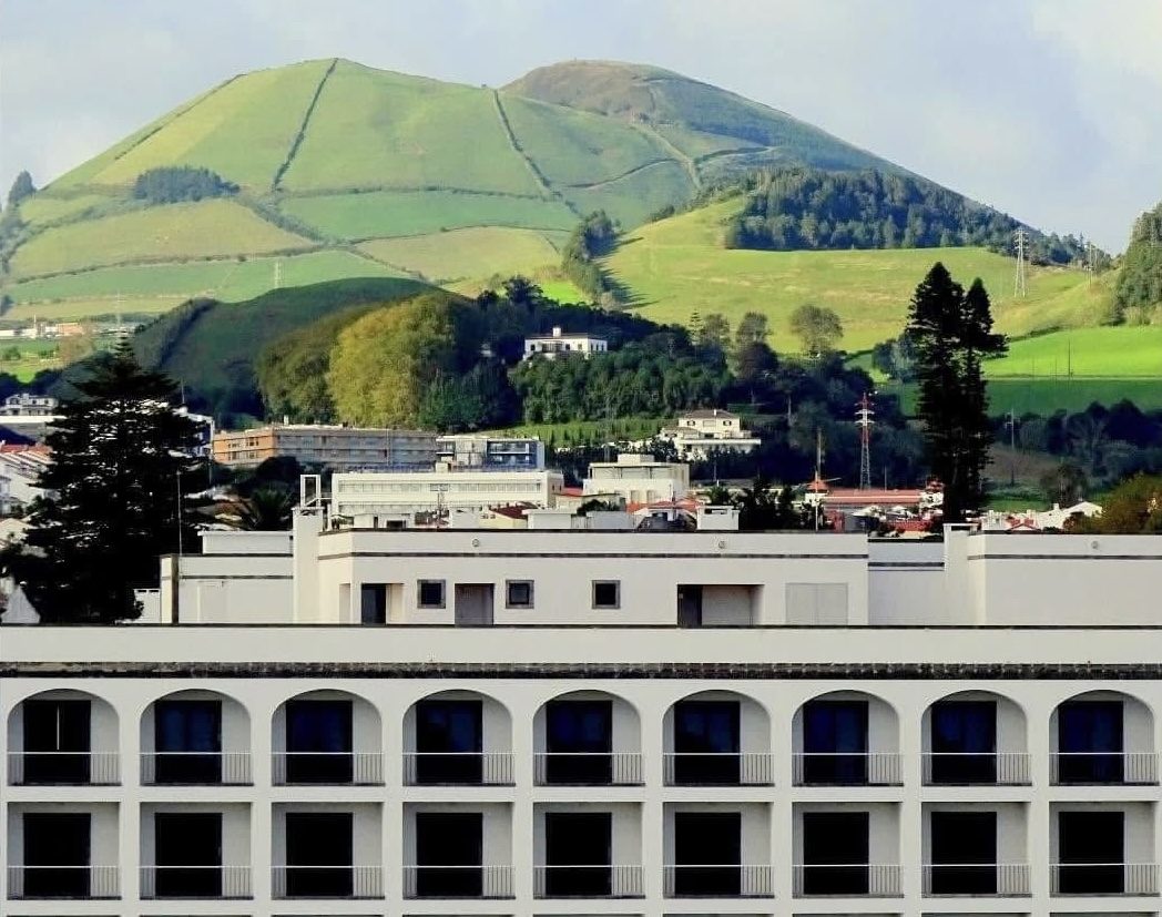 A green volcanic hill above a town in the Azores