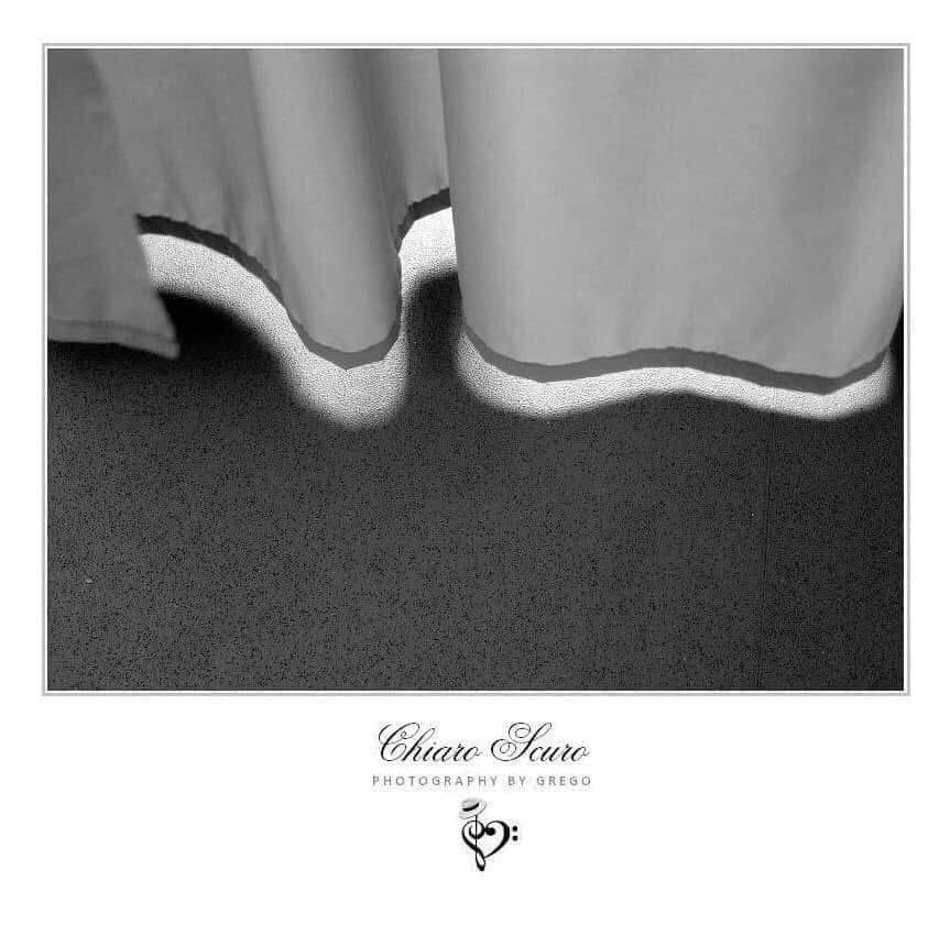 Light spilling under a pair of curtains onto a dark carpet