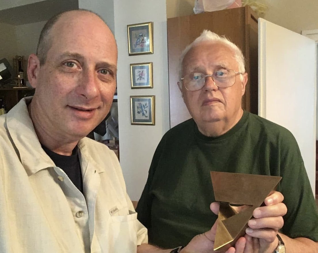 Grego and Professor Szilassi holding a copper model of the Szilassi polyhedron