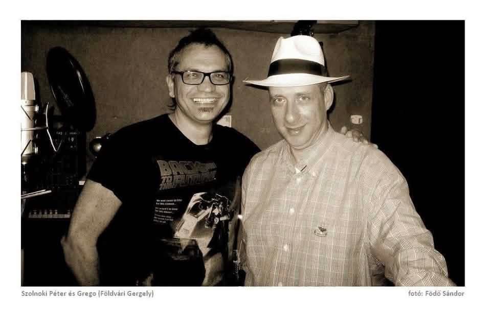 Péter Szolnoki and Grego side by side in the studio, Grego in a white hat